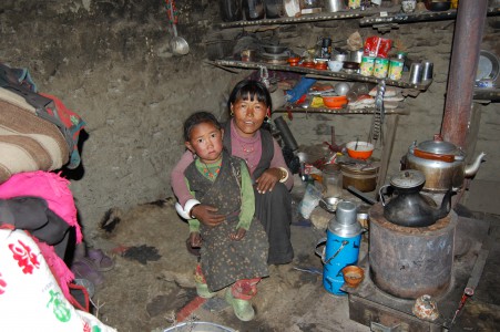 Lamu G. mit ihrer jüngsten Tochter in ihrer dunklen und kalten Behausung. 